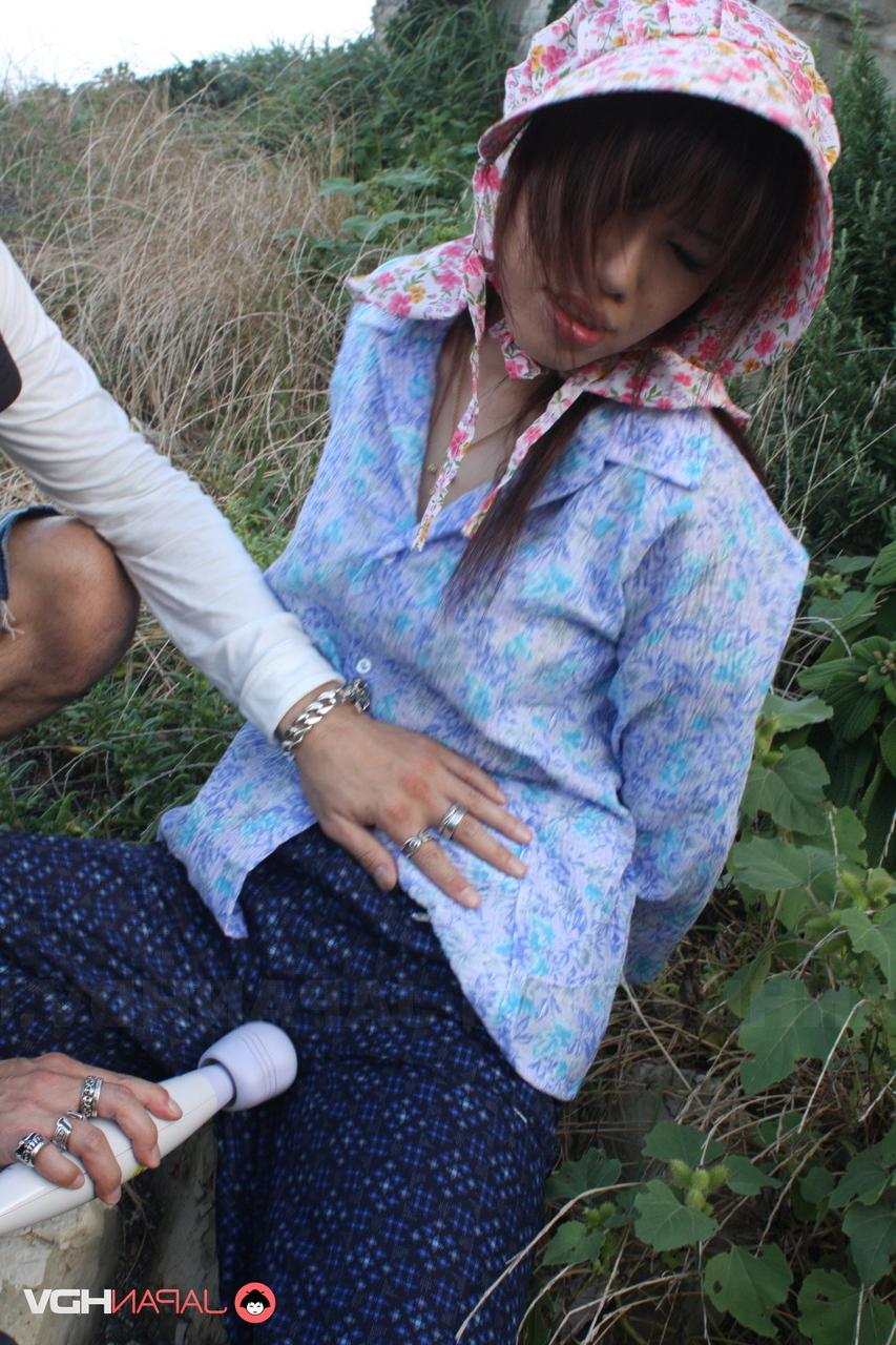 15P Chica japonesa se masturba a través de sus pantalones con botas de goma y un gorro