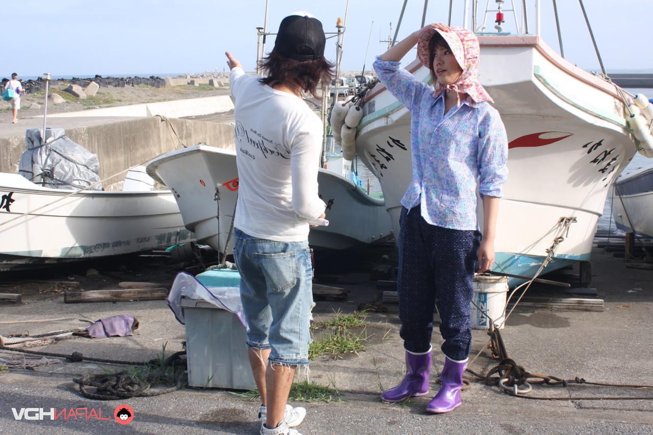 15P Chica japonesa se masturba a través de sus pantalones con botas de goma y un gorro