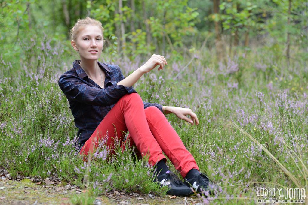 20P Una joven solitaria se arregla el maquillaje antes de modelar desnuda en el bosque