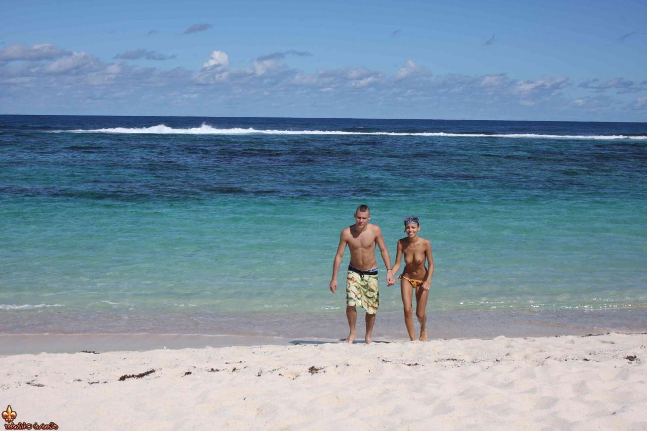 12P Caucasian girl shows the bottoms of her sand covered feet on a beach