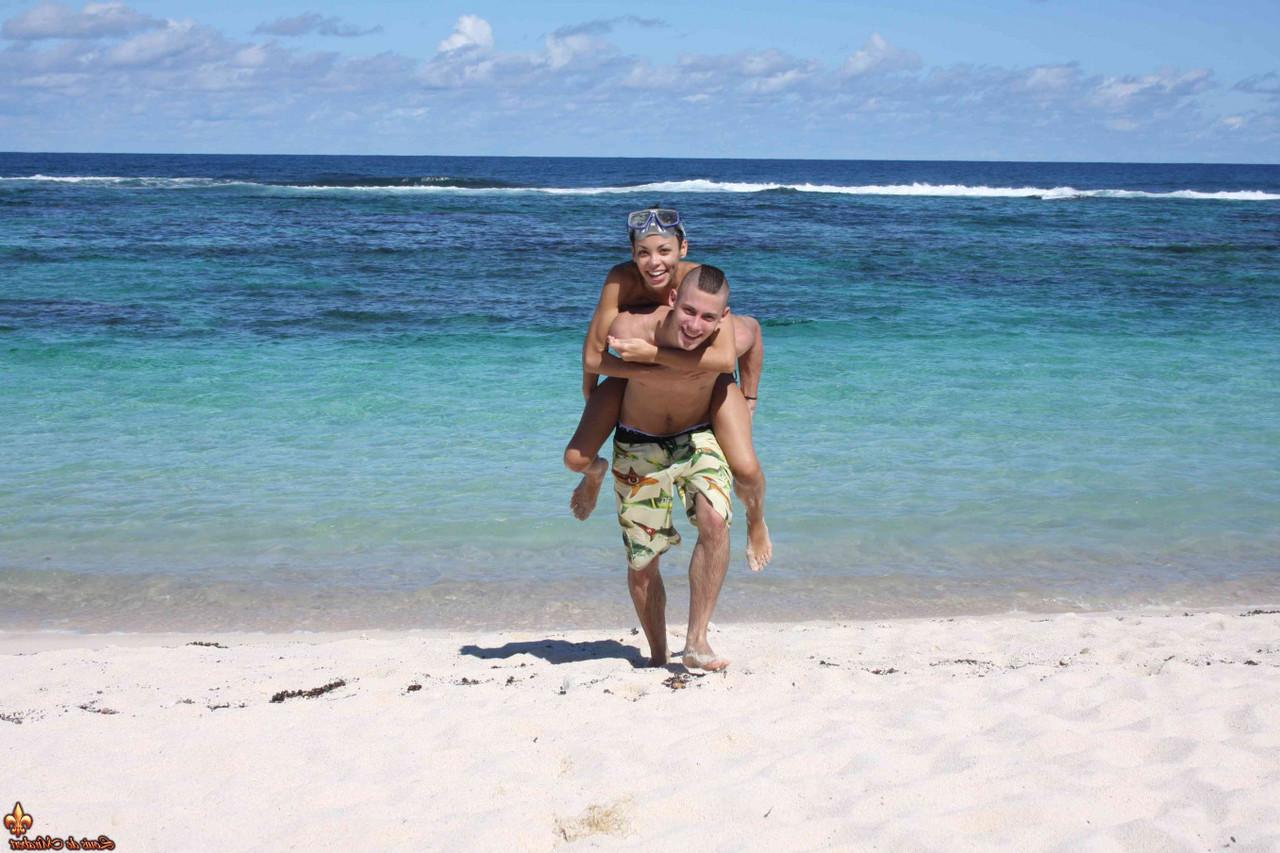 12P Caucasian girl shows the bottoms of her sand covered feet on a beach