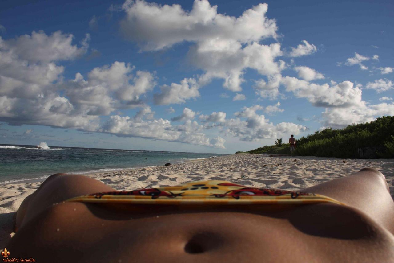 12P Caucasian girl shows the bottoms of her sand covered feet on a beach