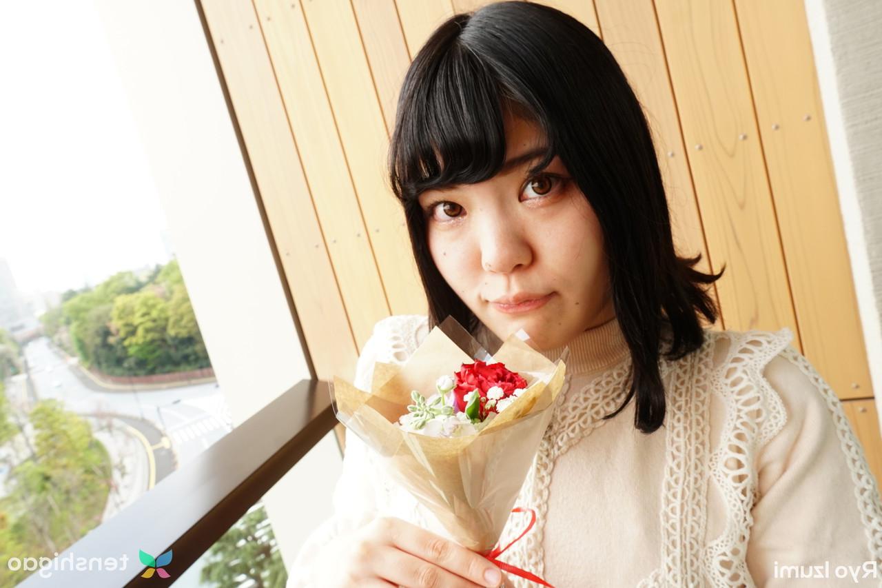 15P Das bezaubernde japanische Mädchen Ryo Izumi hält einen Blumenstrauß in der Hand, während sie nicht nackt ist
