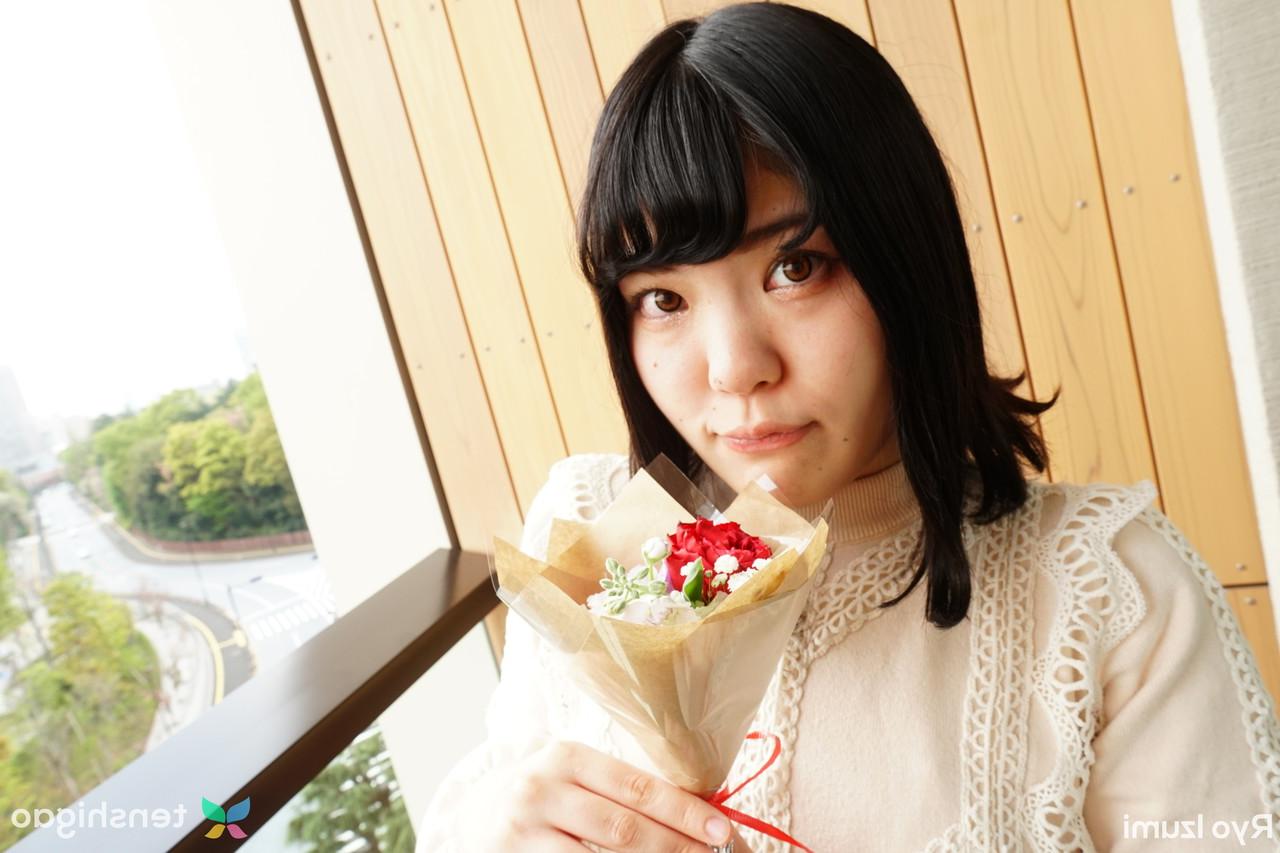 15P Das bezaubernde japanische Mädchen Ryo Izumi hält einen Blumenstrauß in der Hand, während sie nicht nackt ist