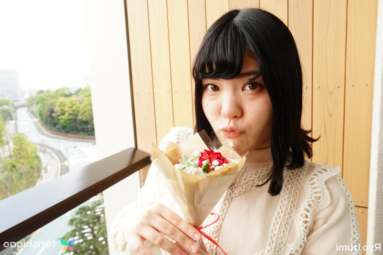 15P Das bezaubernde japanische Mädchen Ryo Izumi hält einen Blumenstrauß in der Hand, während sie nicht nackt ist