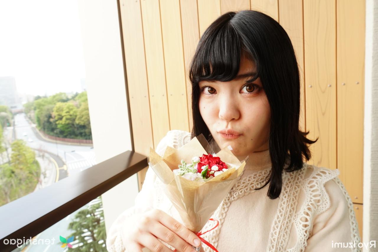 15P Das bezaubernde japanische Mädchen Ryo Izumi hält einen Blumenstrauß in der Hand, während sie nicht nackt ist