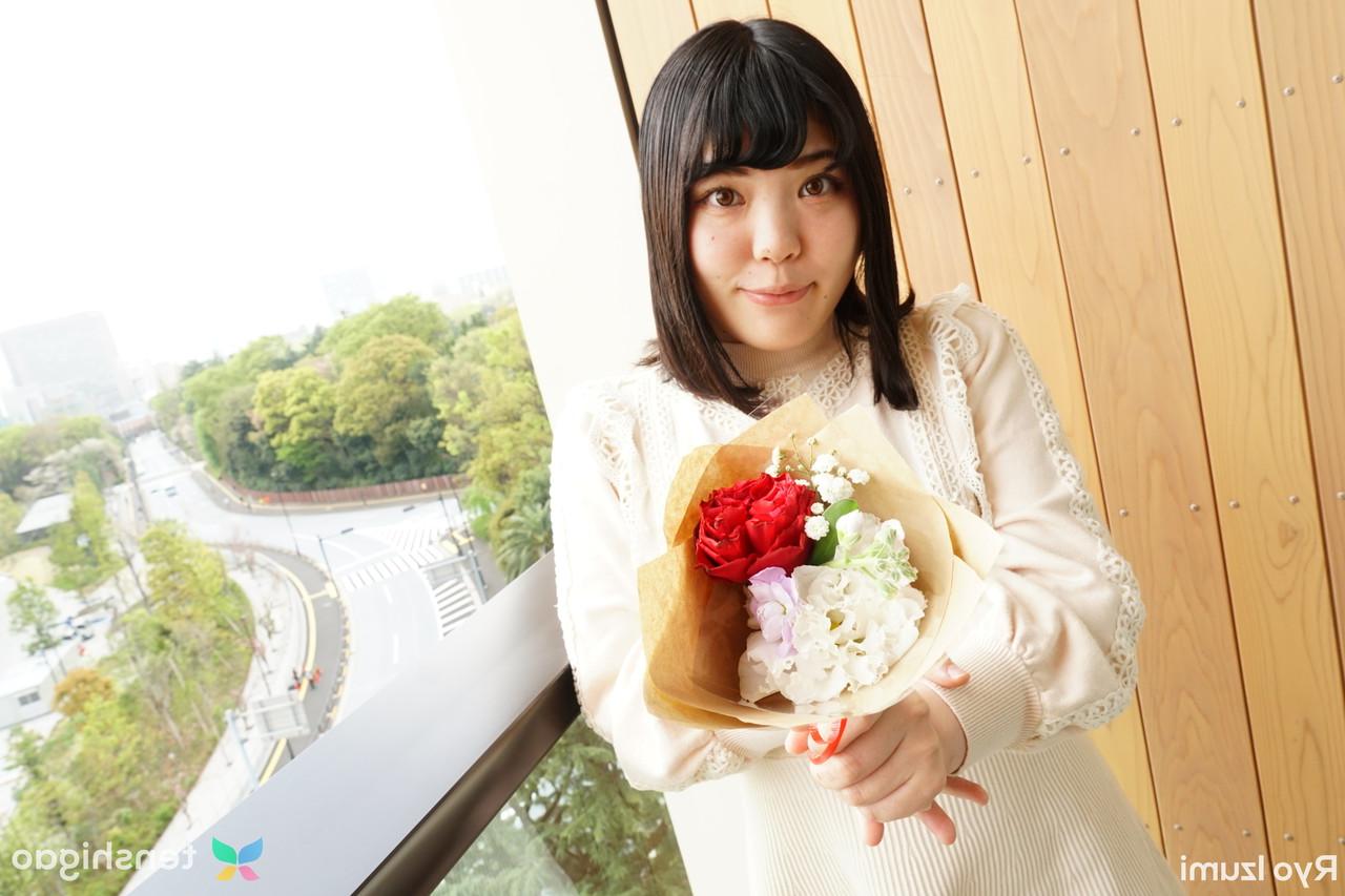 15P Das bezaubernde japanische Mädchen Ryo Izumi hält einen Blumenstrauß in der Hand, während sie nicht nackt ist