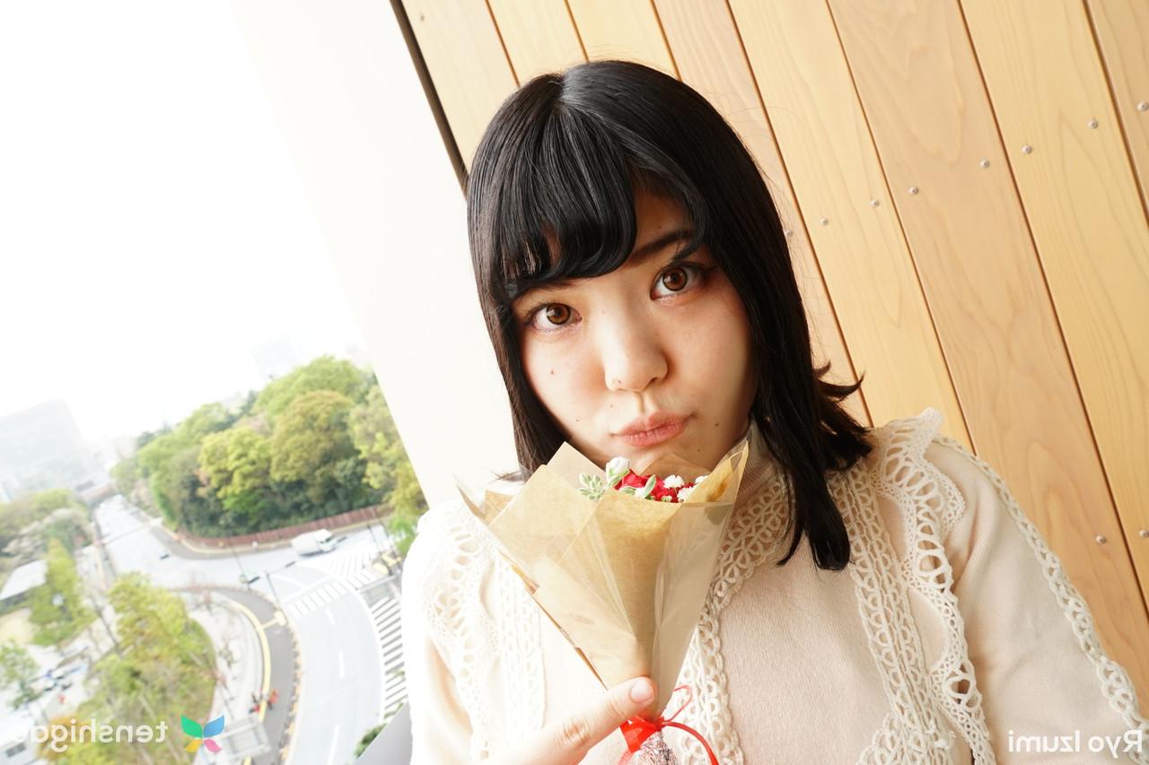 15P Das bezaubernde japanische Mädchen Ryo Izumi hält einen Blumenstrauß in der Hand, während sie nicht nackt ist