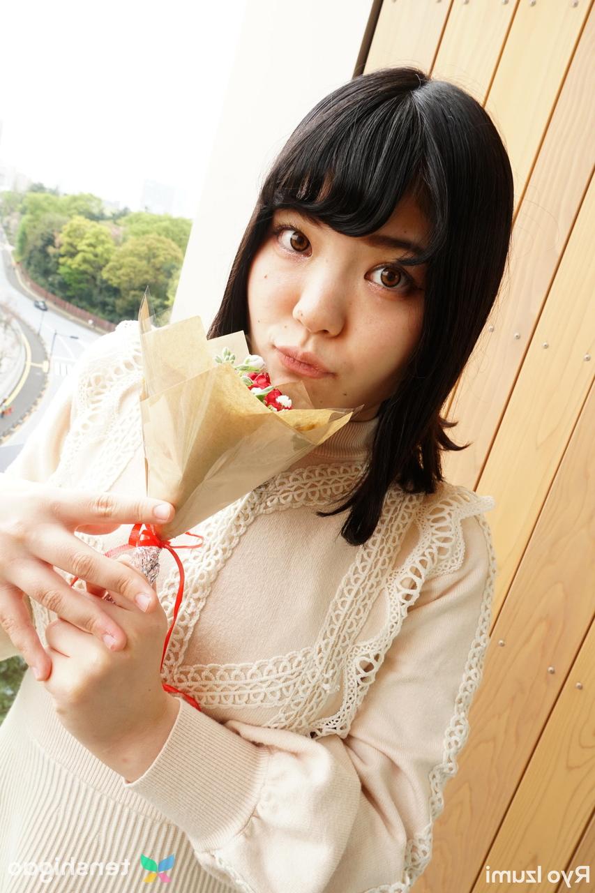 15P Das bezaubernde japanische Mädchen Ryo Izumi hält einen Blumenstrauß in der Hand, während sie nicht nackt ist