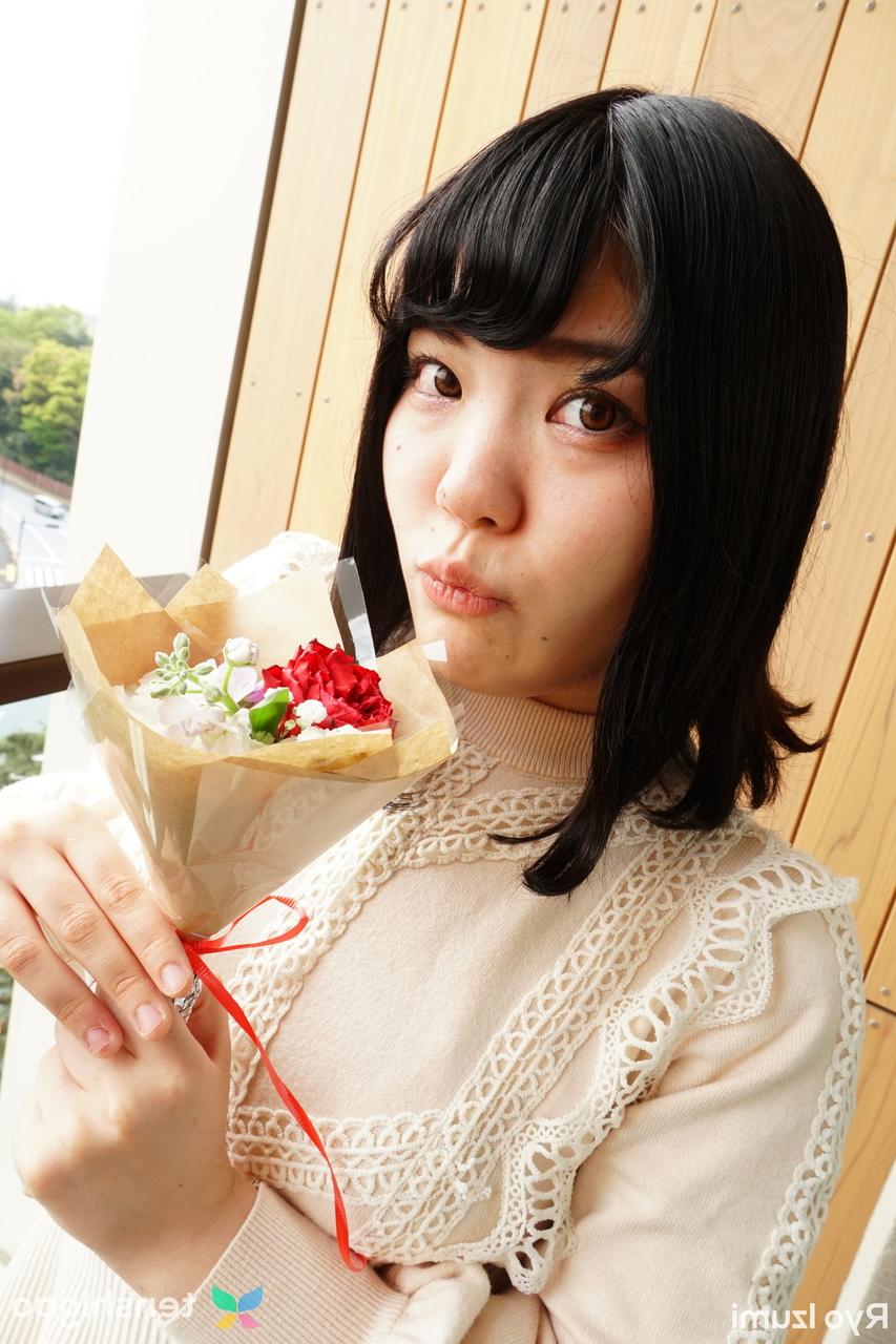 15P Das bezaubernde japanische Mädchen Ryo Izumi hält einen Blumenstrauß in der Hand, während sie nicht nackt ist