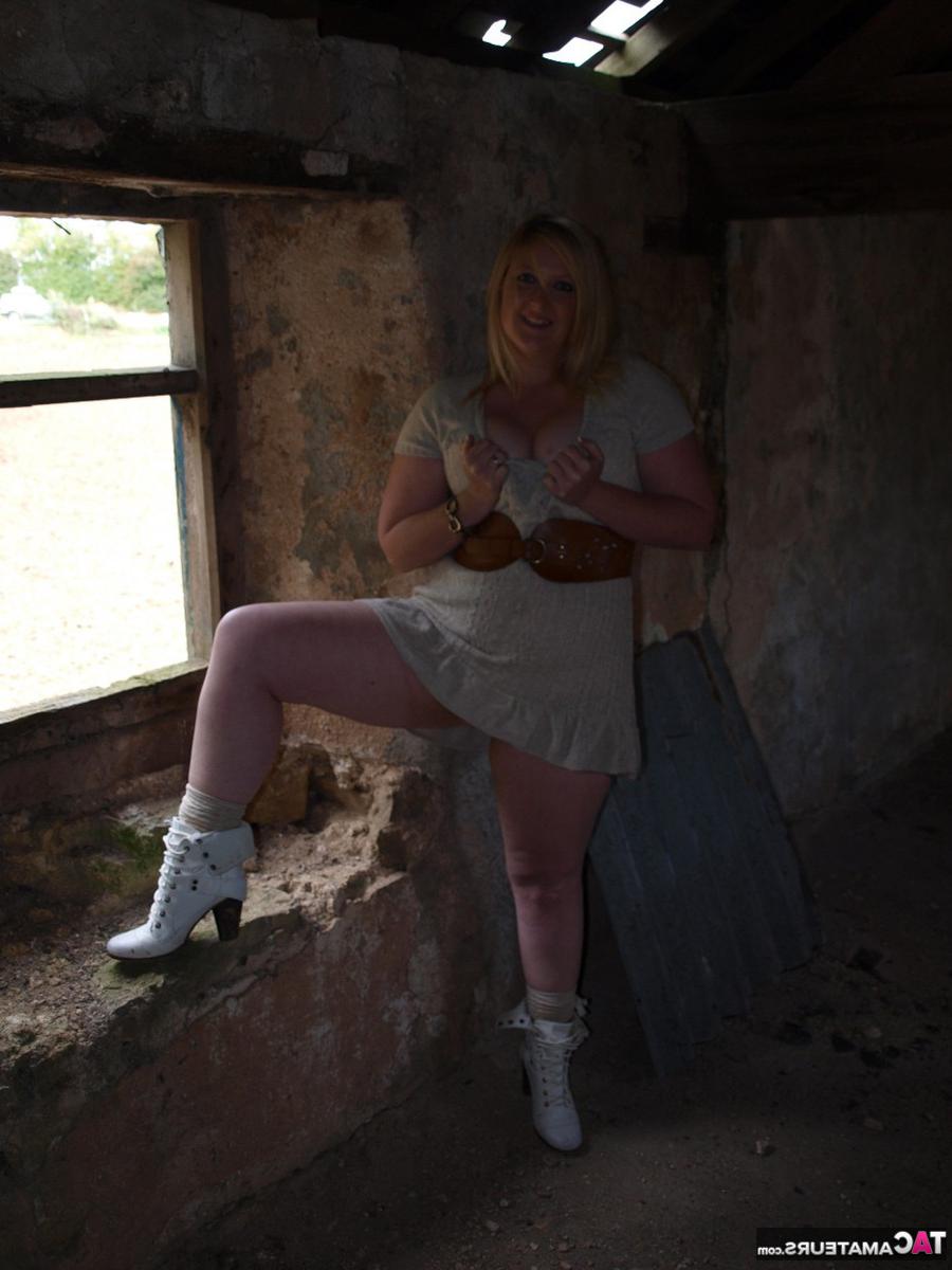 16P Samantha, blonde en surpoids, se déshabille devant la porte d'un immeuble abandonné.