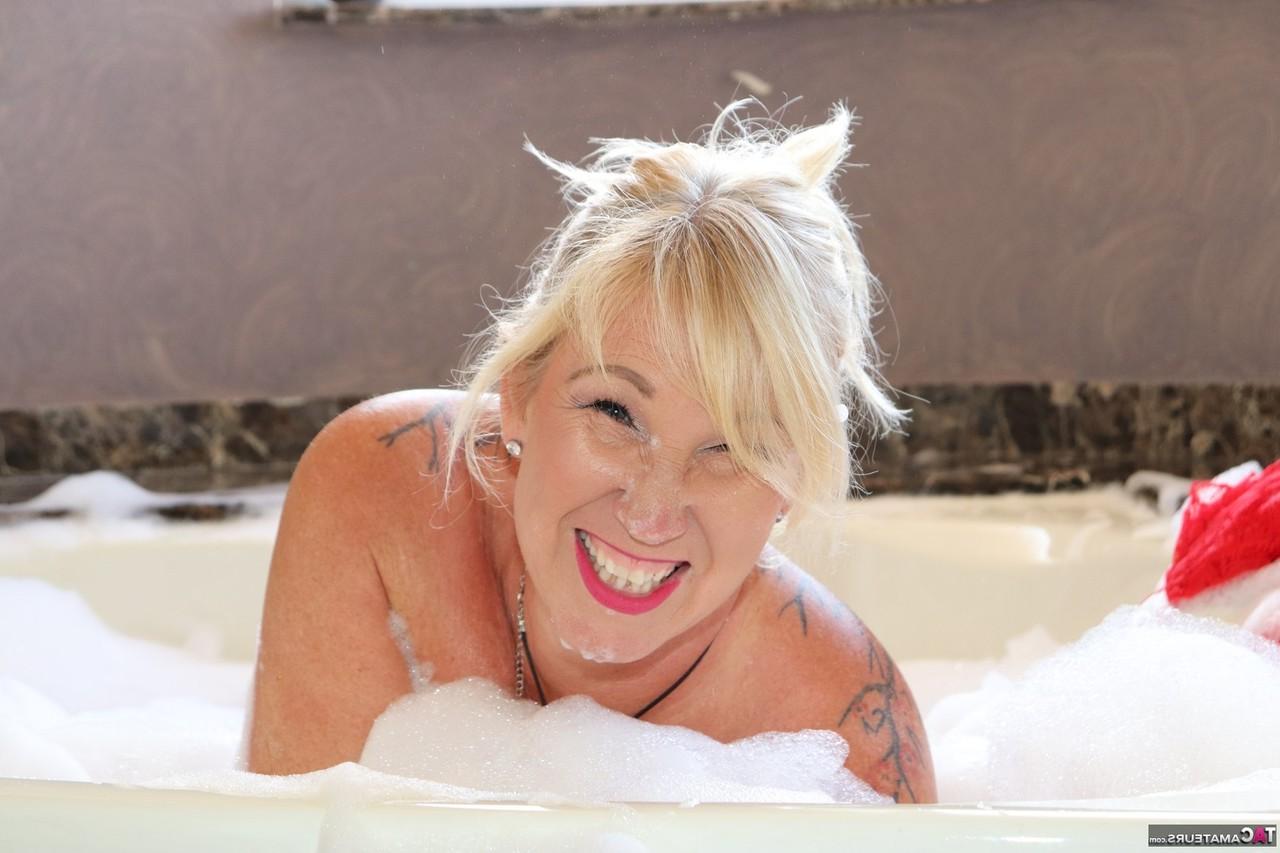 16P Melody, une grosse blonde plus âgée, prend un bain moussant à poil.