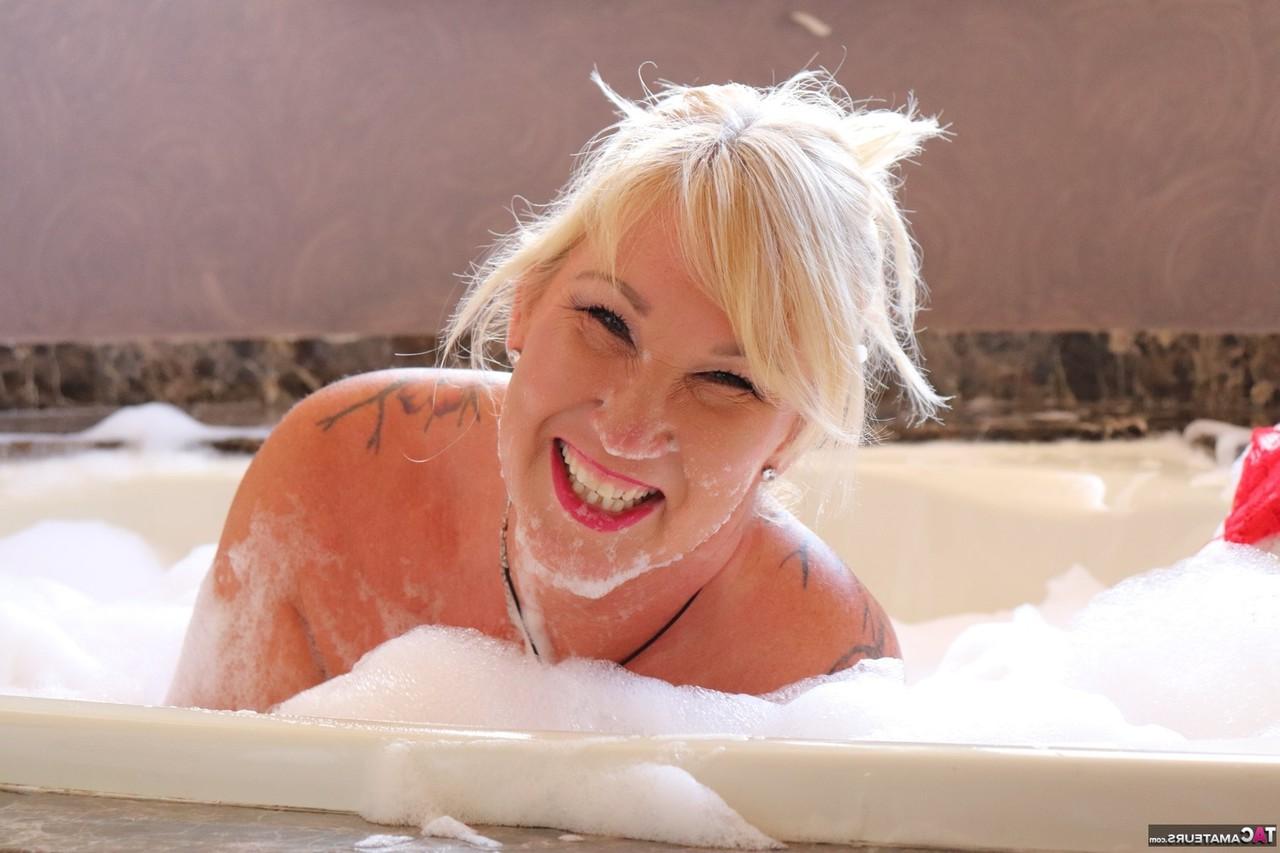 16P Melody, une grosse blonde plus âgée, prend un bain moussant à poil.