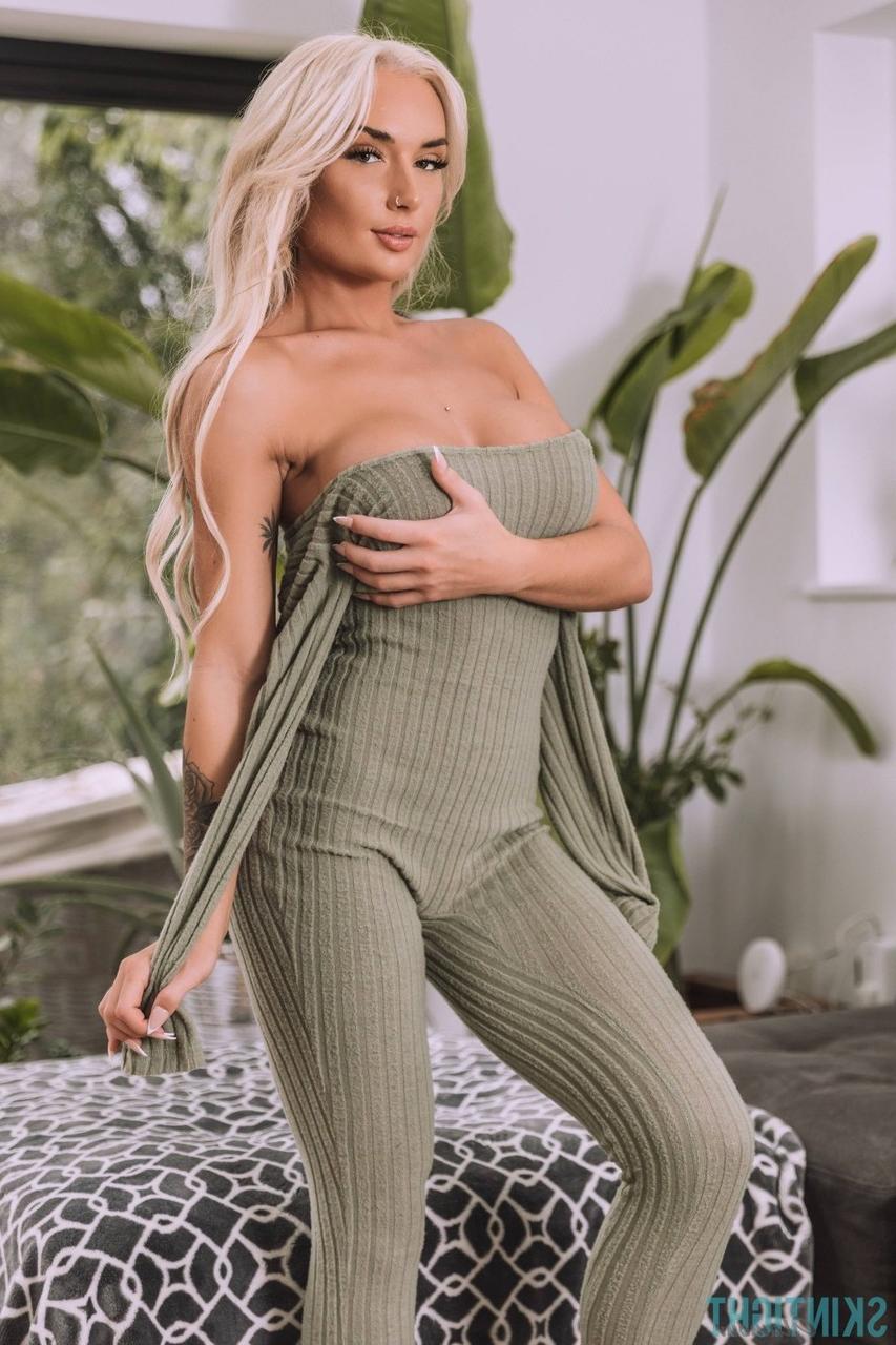 12P La chaude blonde Charlotte Stevens libère son superbe corps de sa tenue moulante.