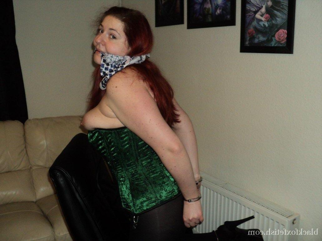 16P Chubby redhead sports a cleave gag with her wrists handcuffed behind her back
