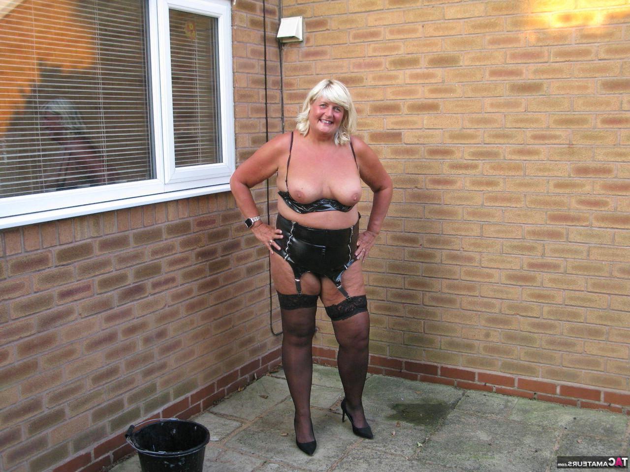 20P Chrissy Uk, blonde mature et pulpeuse, se met seins nus en lavant les fenêtres extérieures.