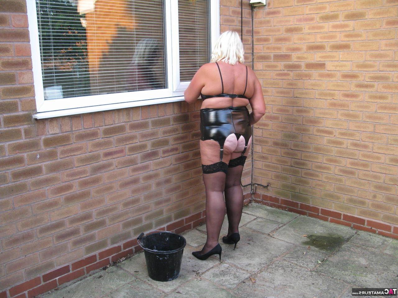 20P Chrissy Uk, blonde mature et pulpeuse, se met seins nus en lavant les fenêtres extérieures.