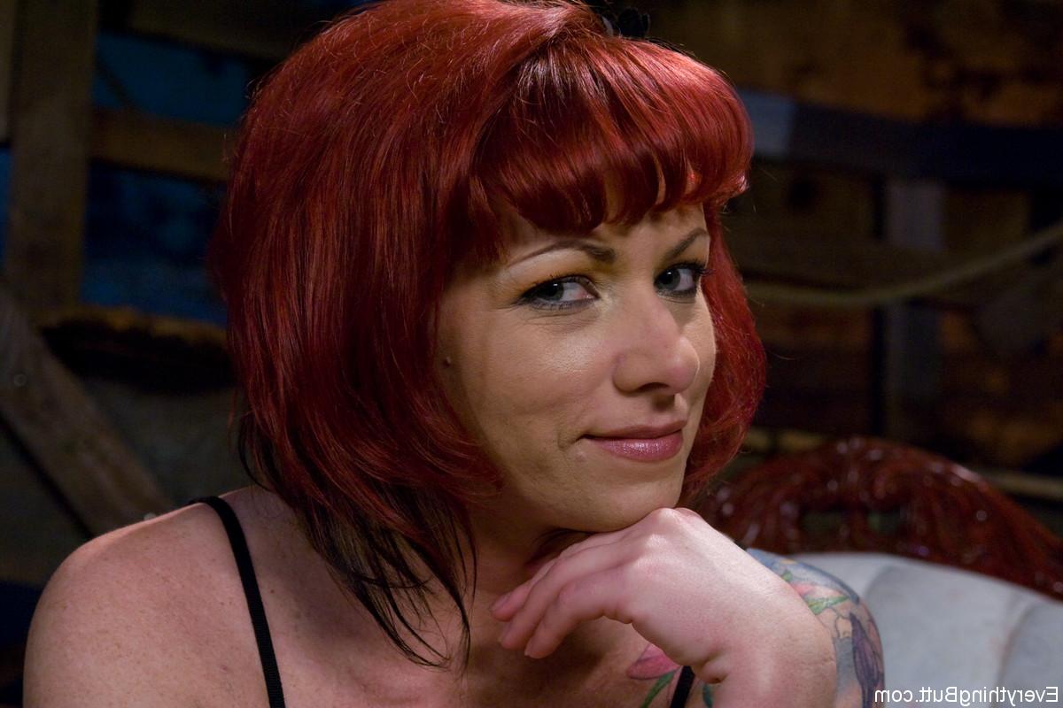 16P Tattooed redhead Kylie Ireland flashes an upskirt butt cheek on a sofa