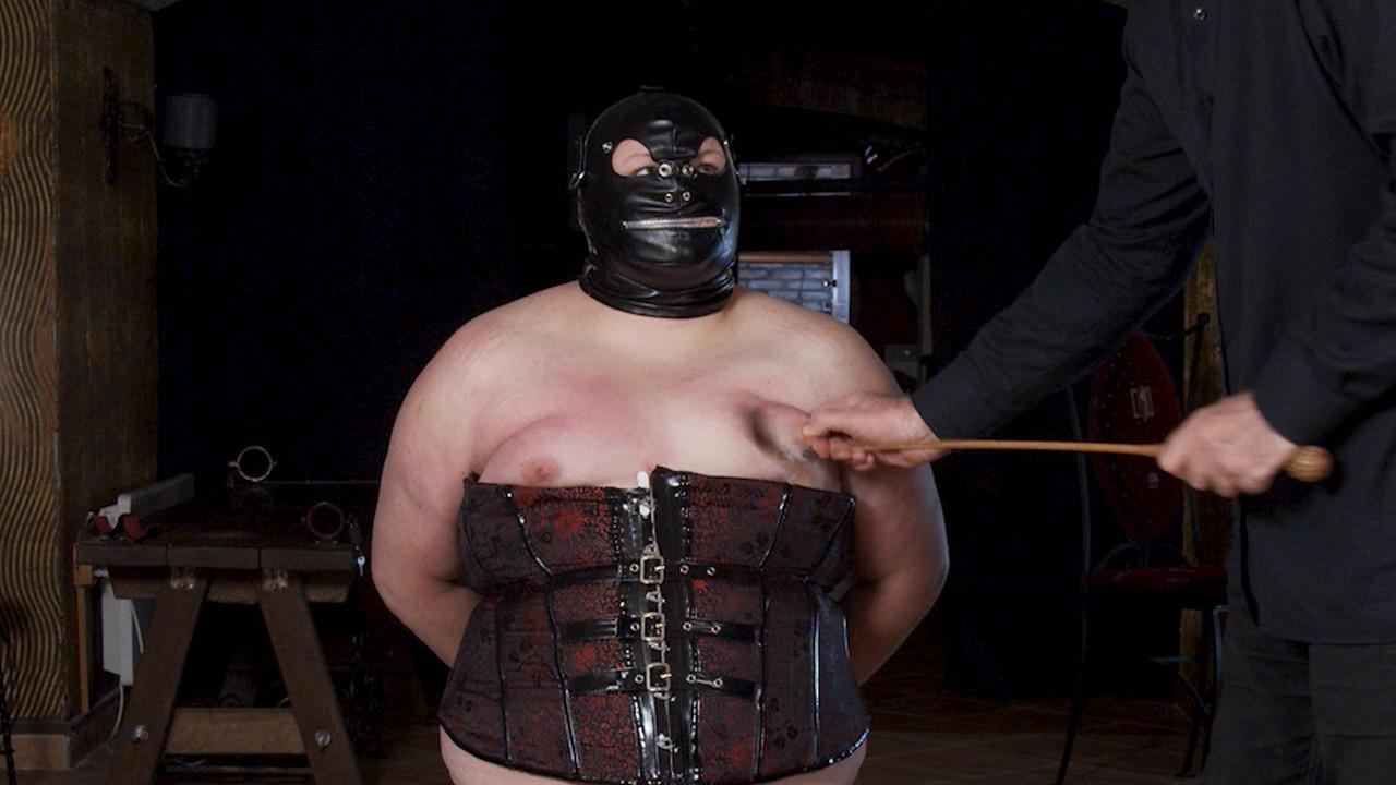 14P Une grosse femme mature portant un masque se fait canner et serrer les seins pendant qu'elle est ligotée