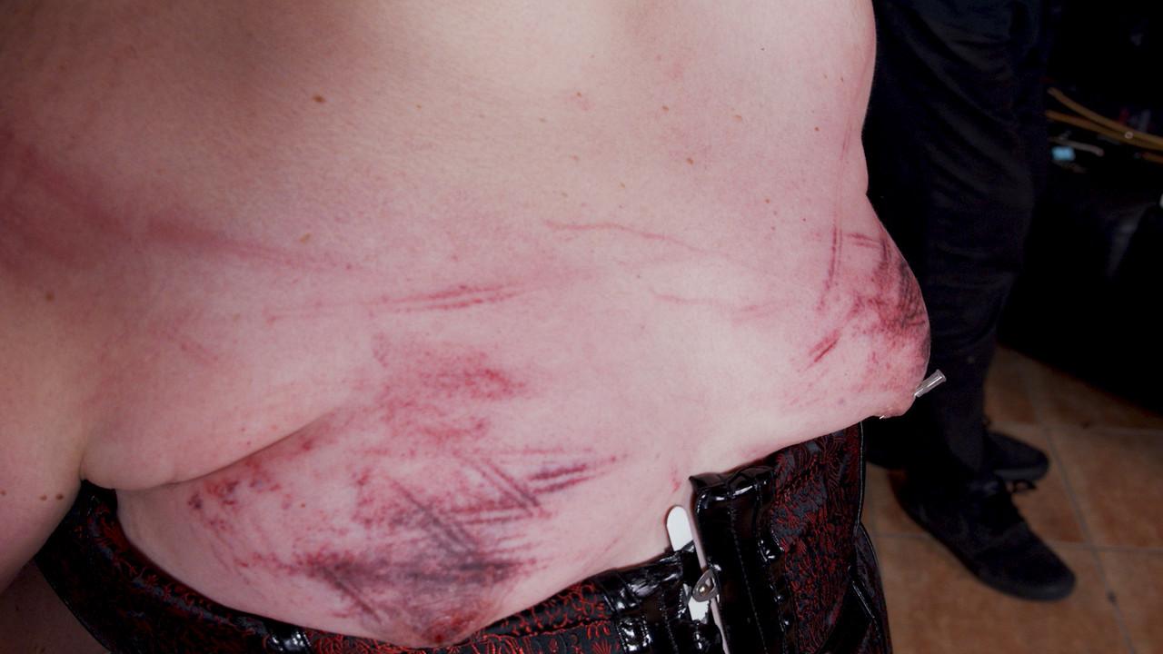 14P Une grosse femme mature portant un masque se fait canner et serrer les seins pendant qu'elle est ligotée