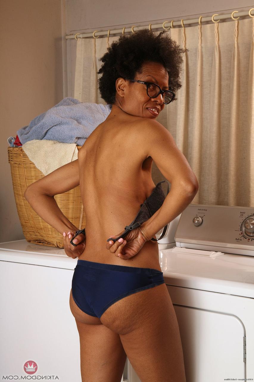 20P Ebony MILF with glasses Ariela flaunts her hairy cunt while doing laundry