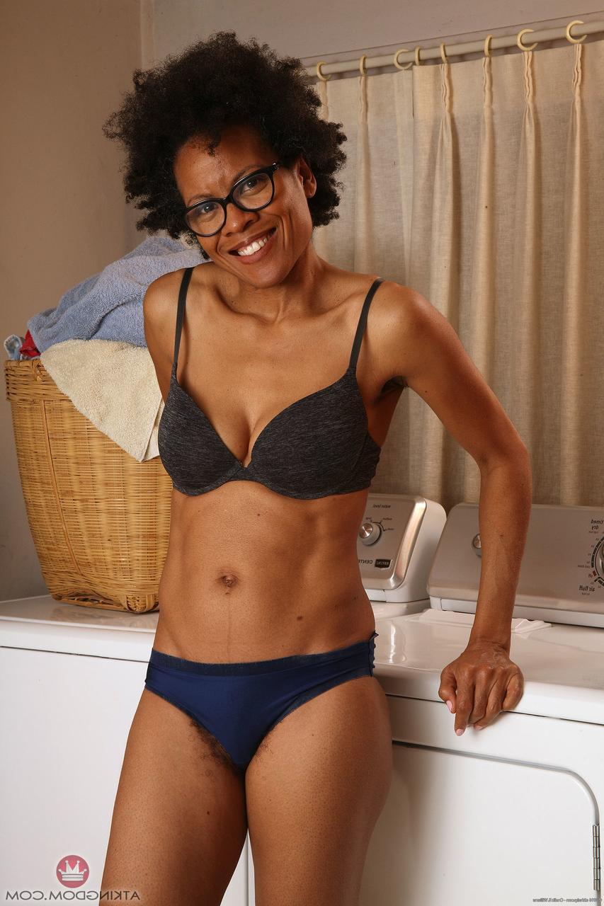 20P Ebony MILF with glasses Ariela flaunts her hairy cunt while doing laundry