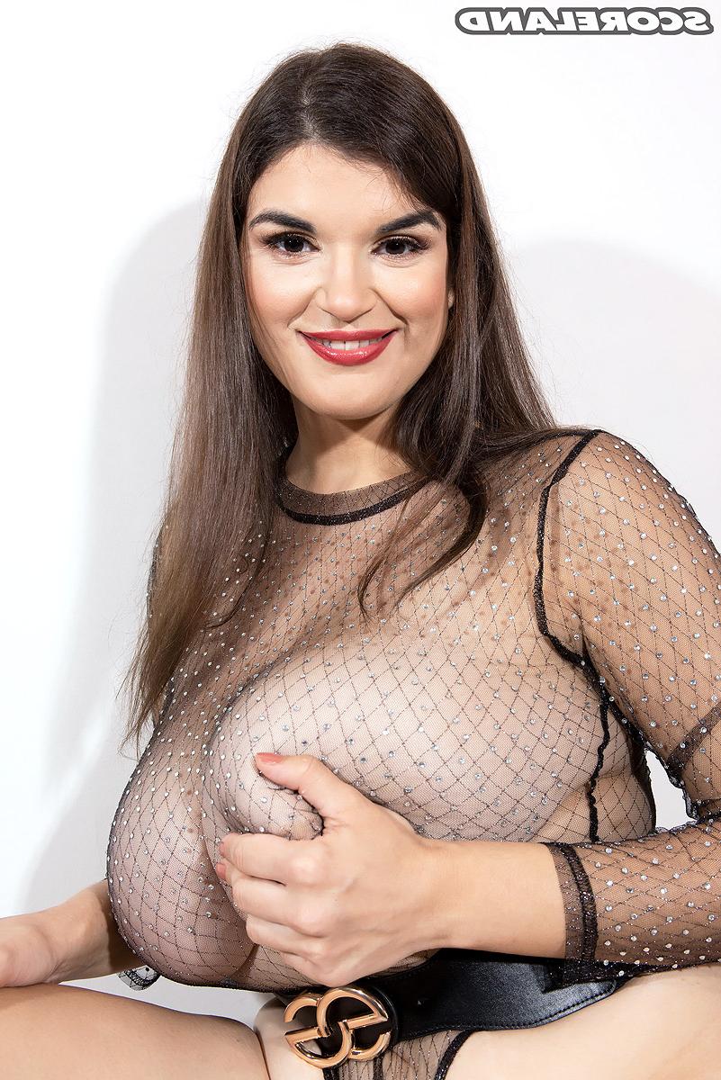 16P Pretty brunette Jenni Noble sets her giant boobs loose of a sheer bodysuit