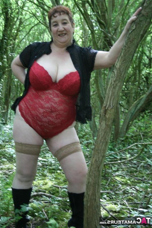 20P Senhora madura Kinky Carol mostra seus peitos enormes e bunda em meio à vegetação rasteira