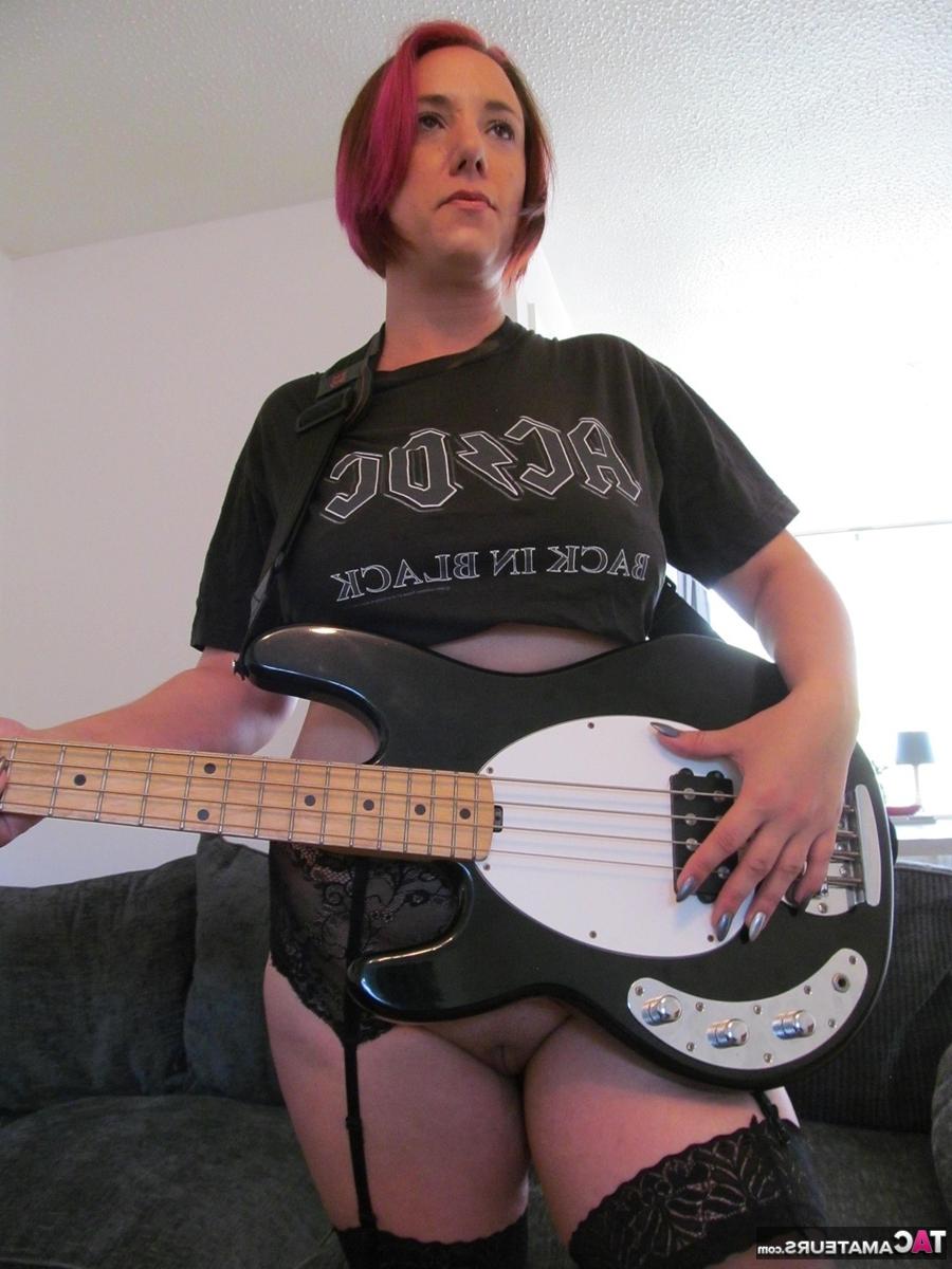 16P La bassiste Sara Banks montre ses seins et sa chatte au sommet d'un lit.
