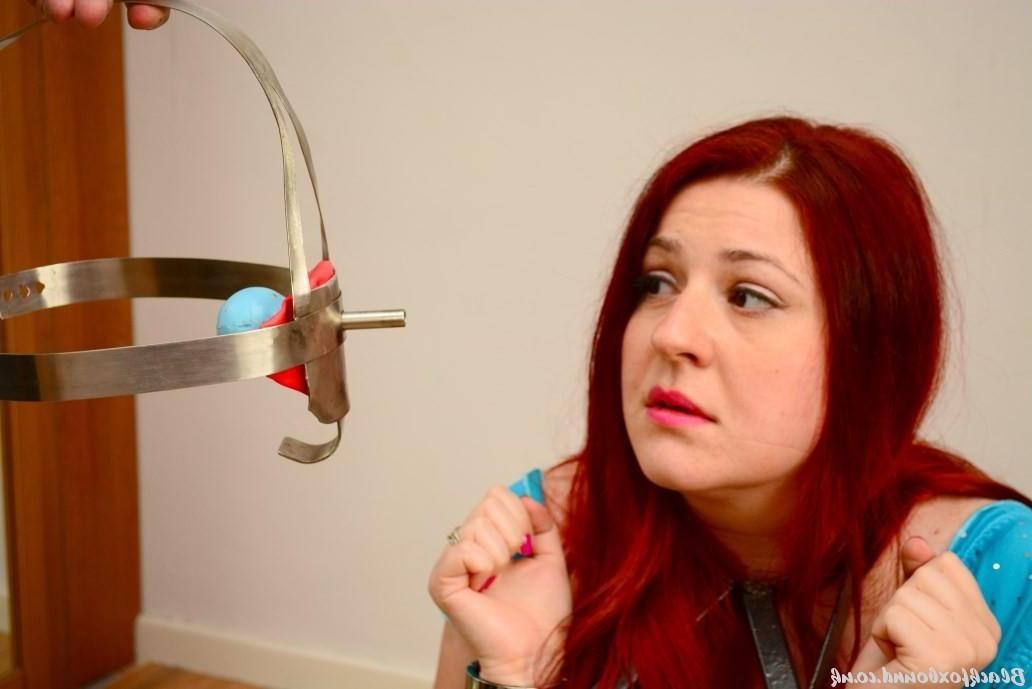 16P Pale redhead is fitted with a medieval looking gag while restrained
