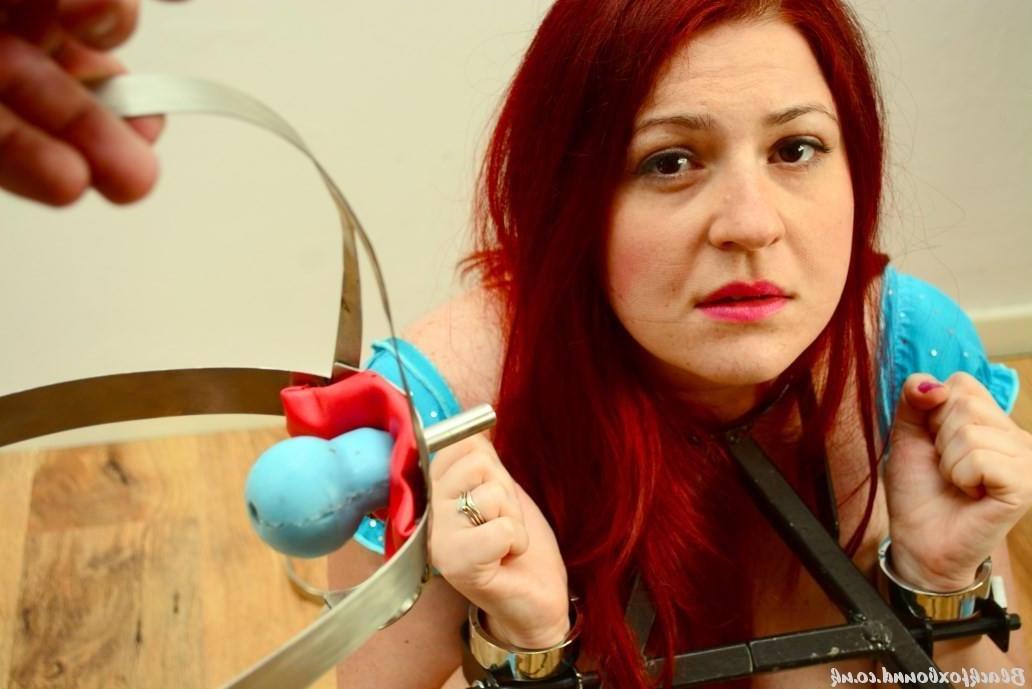 16P Pale redhead is fitted with a medieval looking gag while restrained