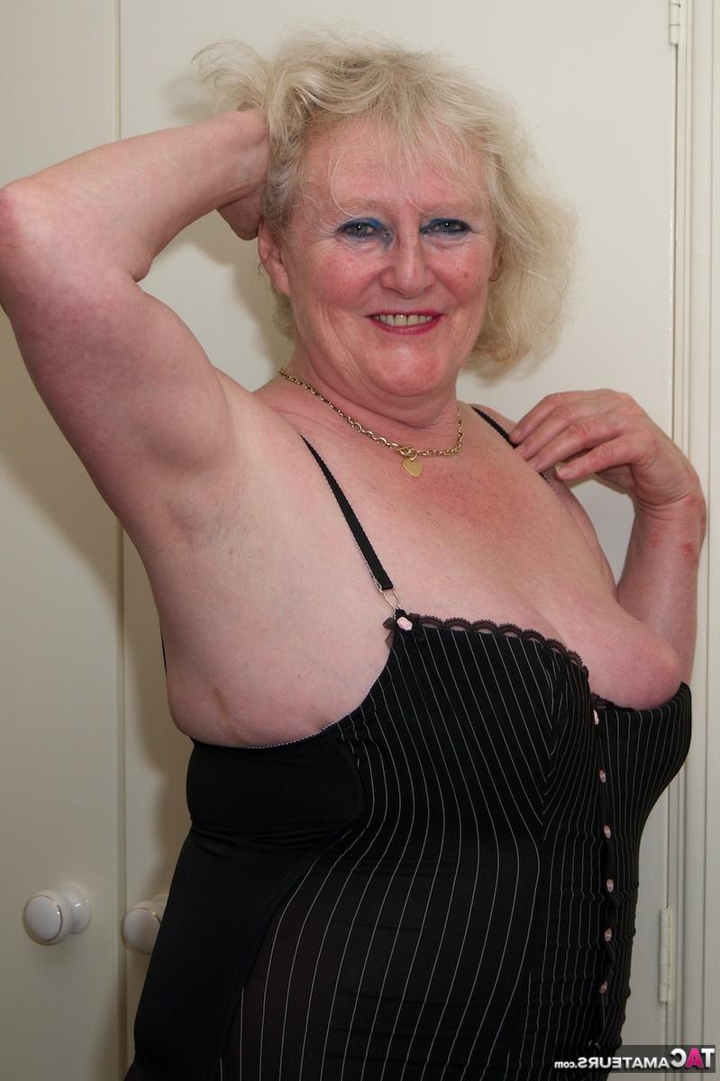 16P La blonde Oma se doigte le vagin sur un lit en bas et talons.