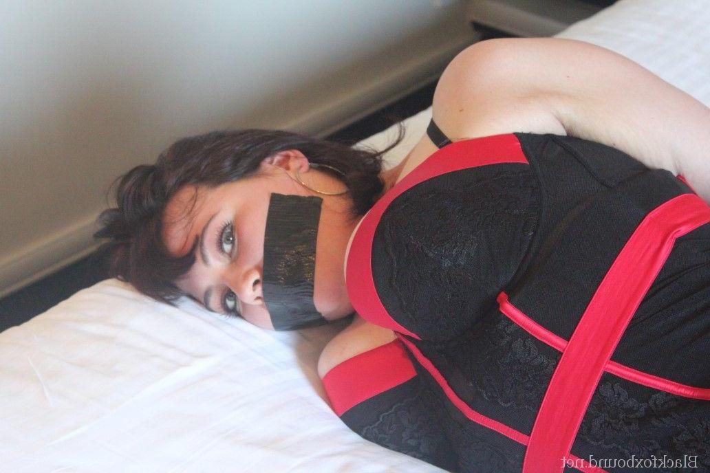 16P Caucasian woman is silenced with duct tape while tied up on a bed in lingerie