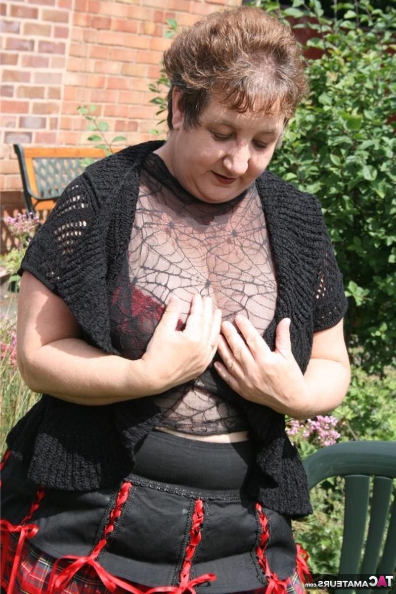 16P Die ältere britische BBW Kinky Carol zeigt ihr Unterrock-Höschen und ihren BH in einem Garten