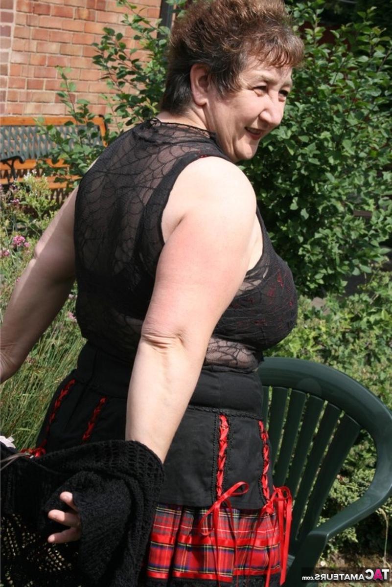 16P Die ältere britische BBW Kinky Carol zeigt ihr Unterrock-Höschen und ihren BH in einem Garten