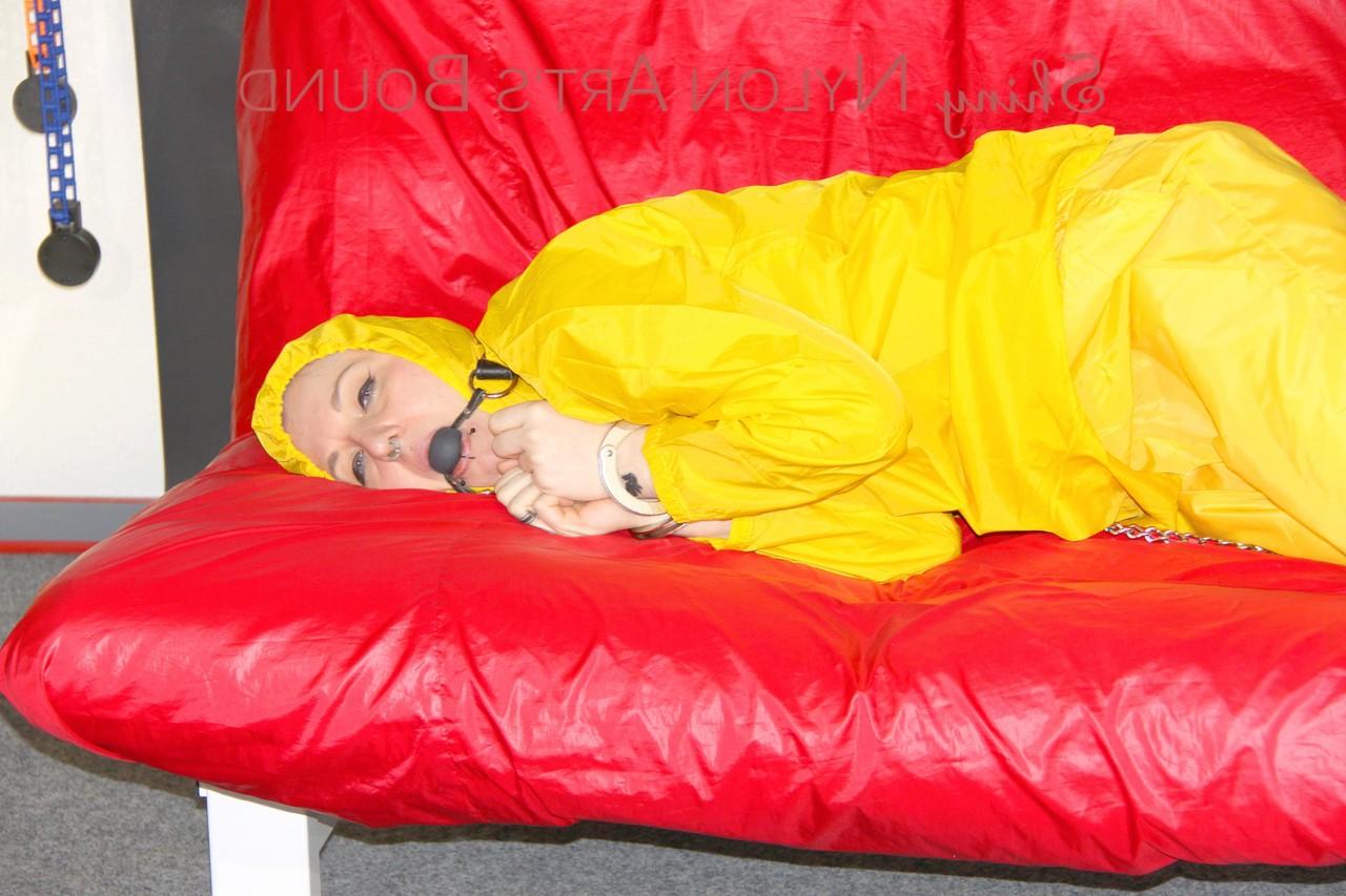 16P White girl is restrained with cuffs and chain while gagged in nylon attire