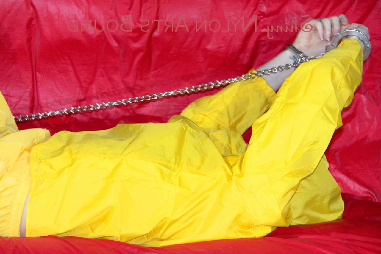 16P White girl is restrained with cuffs and chain while gagged in nylon attire