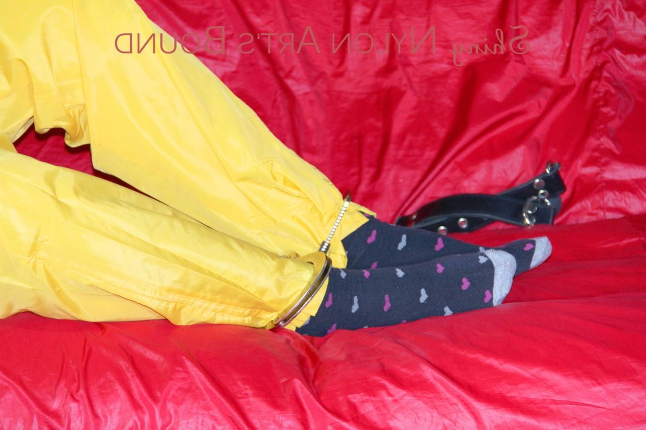 16P White girl is restrained with cuffs and chain while gagged in nylon attire