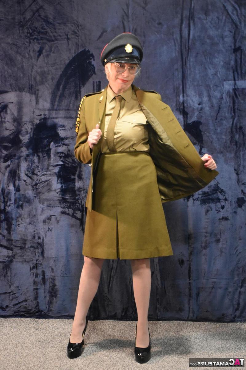 16P Barby Slut, une militaire plus âgée, commence à enlever son uniforme.