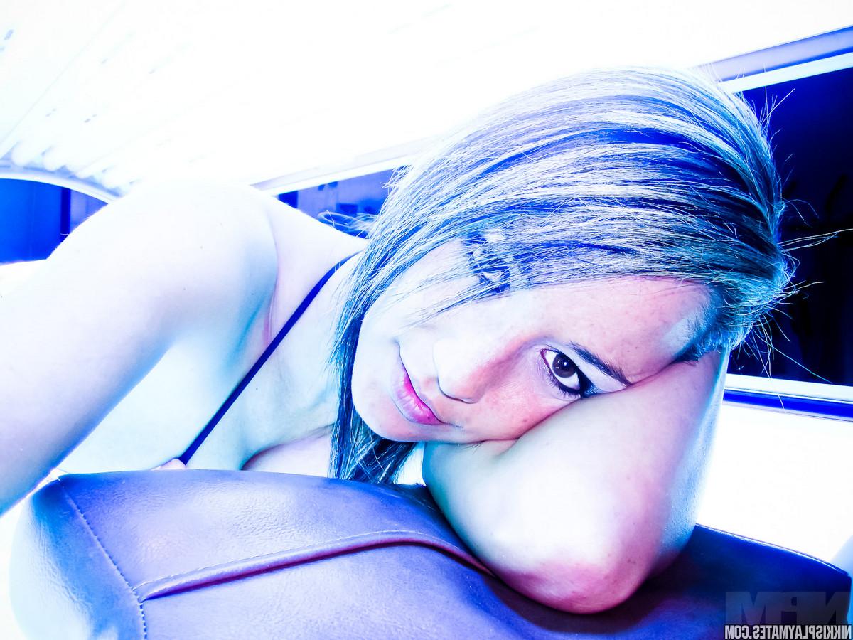 15P L'amatrice Nikki Sims prend des photos taquines sur un lit de bronzage.