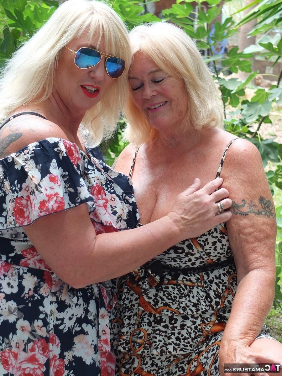 16P Melody, une grosse blonde plus âgée, joue avec les seins de son amante lesbienne sur une terrasse.