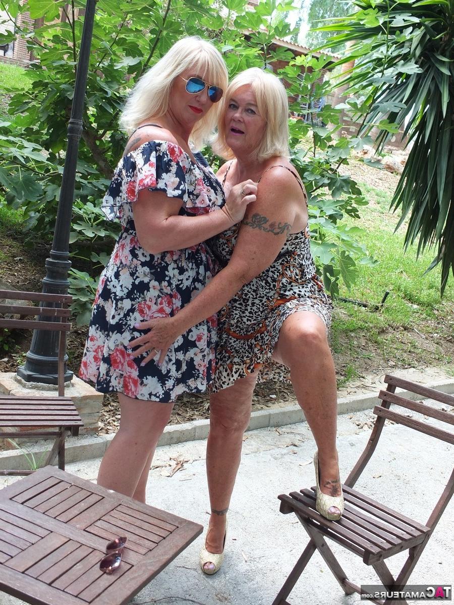 16P Melody, une grosse blonde plus âgée, joue avec les seins de son amante lesbienne sur une terrasse.