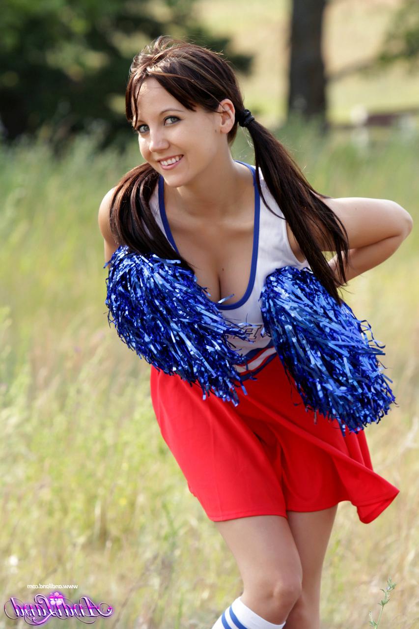 15P Die jugendliche Cheerleaderin Andi Land entblößt auf einem Feld ihre Titten und ihre Muschi