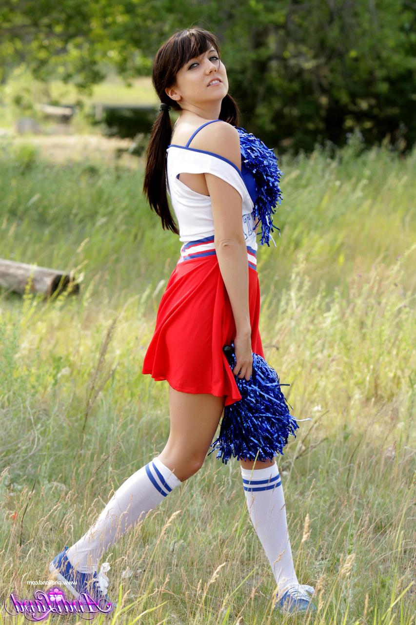 15P Die jugendliche Cheerleaderin Andi Land entblößt auf einem Feld ihre Titten und ihre Muschi