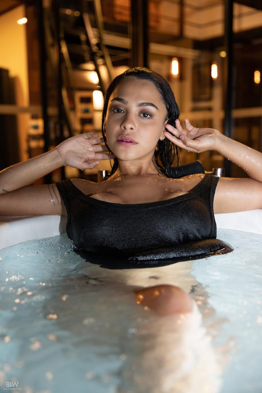 20P La latina sexy Kaley Jones lave ses gros seins et son cul dans un jacuzzi.