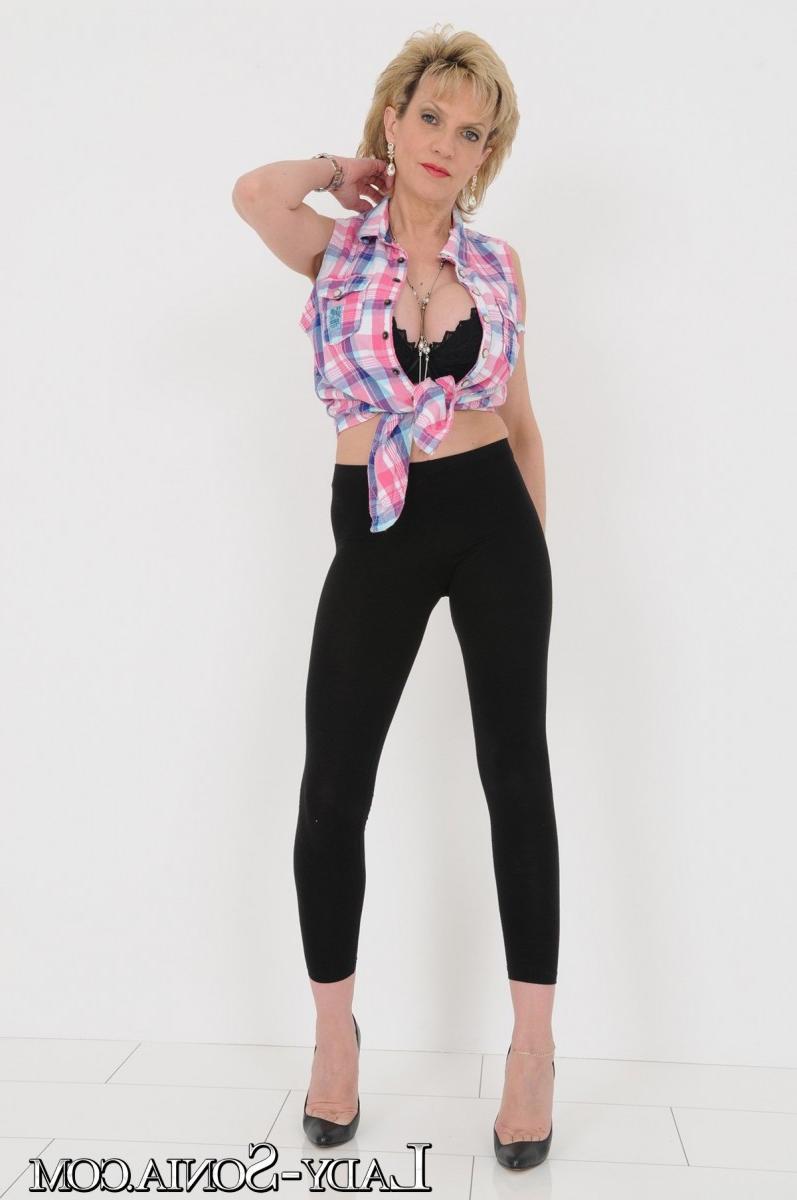 20P La rubia madura lady sonia muestra su escote con leggings y tacones negros