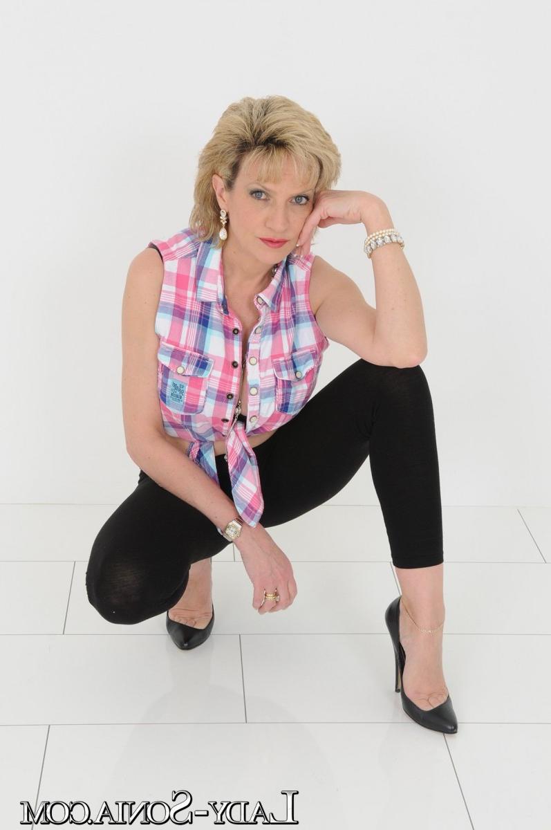 20P La rubia madura lady sonia muestra su escote con leggings y tacones negros