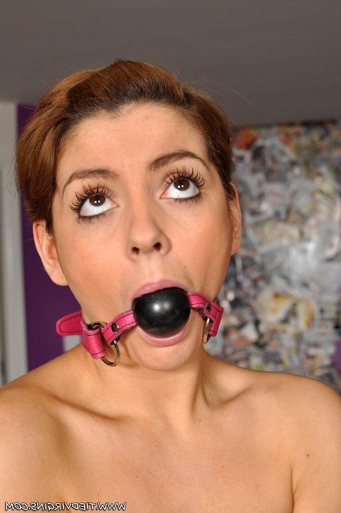 12P Oben ohne und mit kurzen roten Haaren trägt sie einen Ballknebel, während sie mit einem Seil gefesselt ist