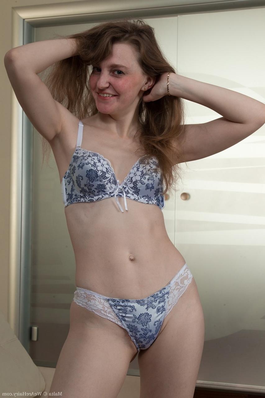 17P A morena amadora esbelta Malta tira a roupa nua no sofá e espalha cooch felpudo