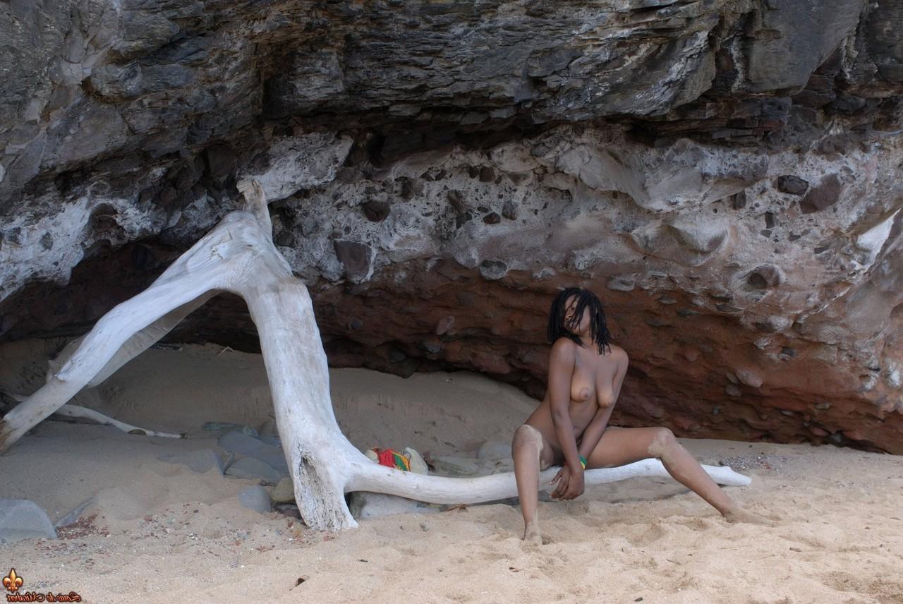 16P A garota negra Diamaa fica completamente nua em madeira flutuante em uma praia